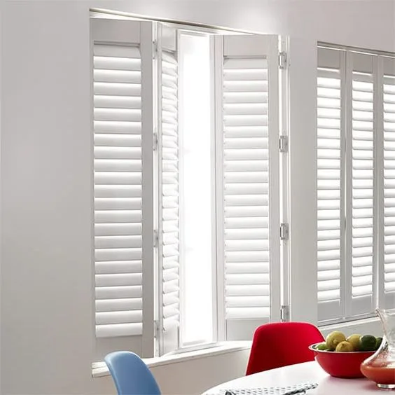 Modern white plantation shutters installed in a bright living room