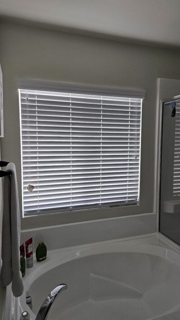 Custom window blinds installed by Blinds by Design near sunny window