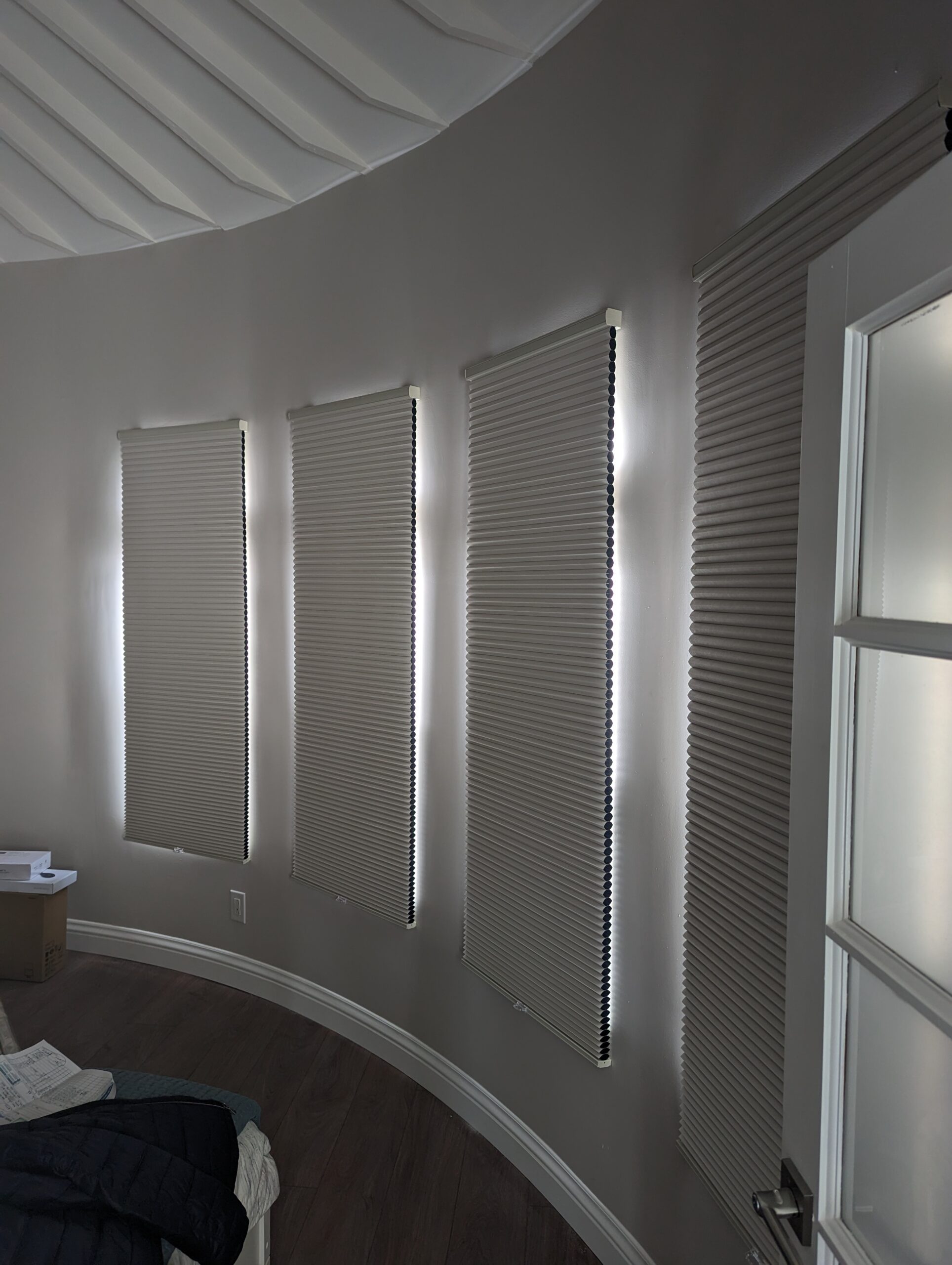 Blinds by Design technician installing custom window shades inside modern home.