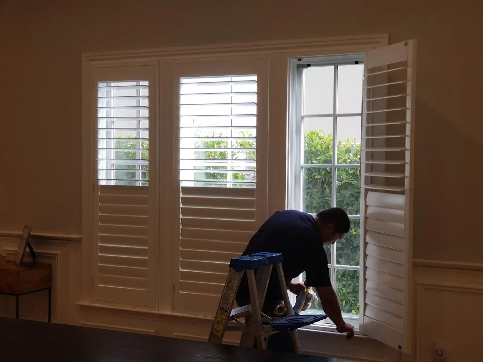White plantation shutters mounted inside a living room