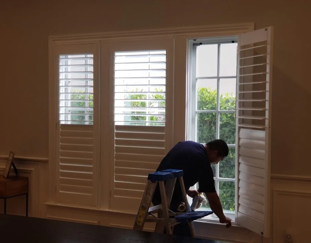 White plantation shutters mounted inside a living room